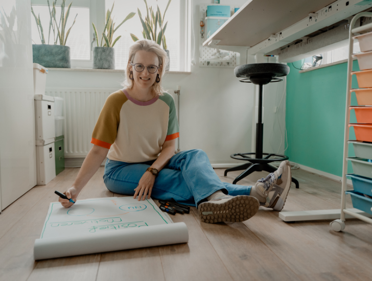 Marielle Tromp op de grond met papier